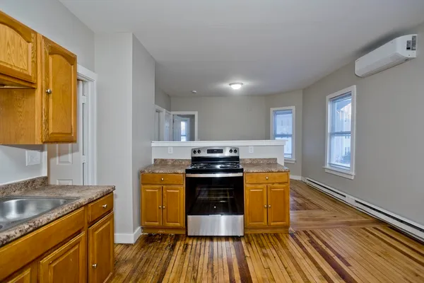 a kitchen with wooden floors wooden cabinets and stainless steel appliances