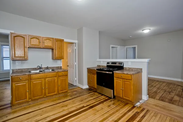 a kitchen with stainless steel appliances granite countertop a stove a sink and a refrigerator