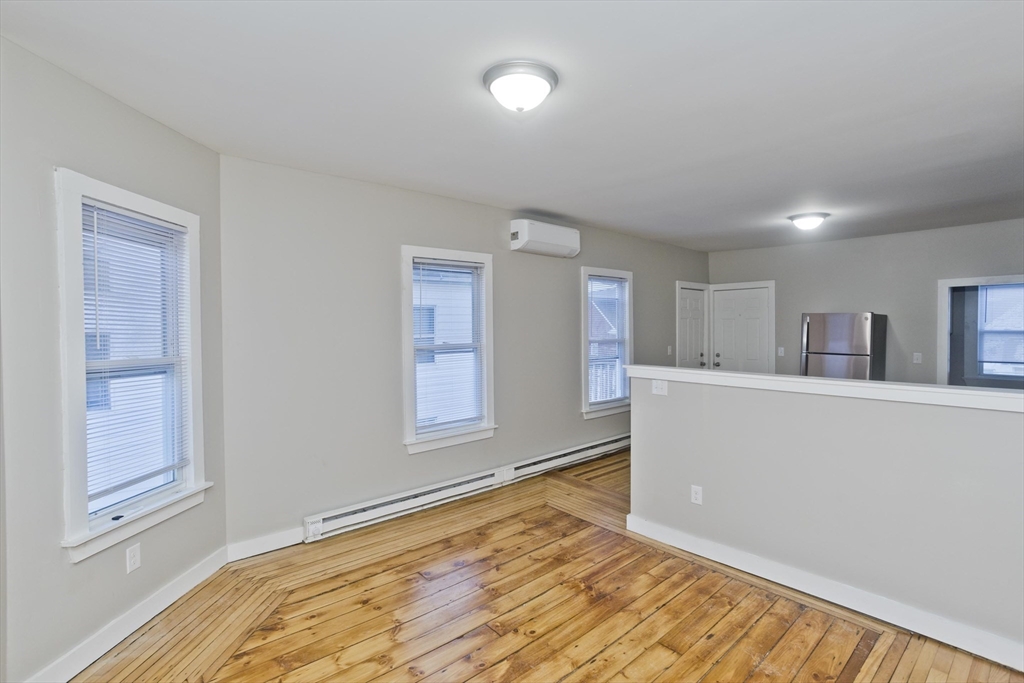 202 Oakland Street Springfield, MA 01108 - Photo 9 of 39 a view of an empty room with window and wooden floor