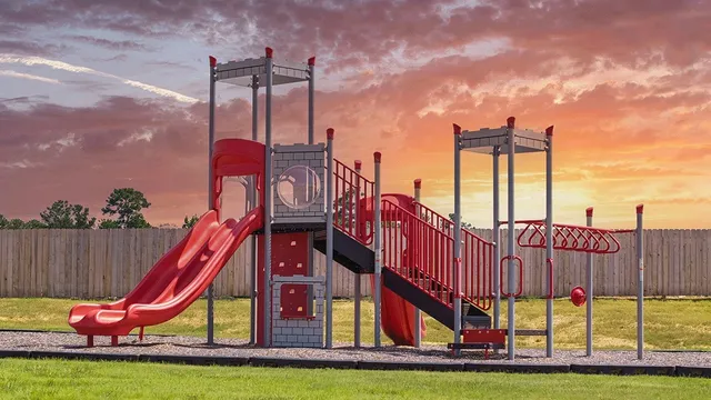 a view of a park with a slide and potted plants