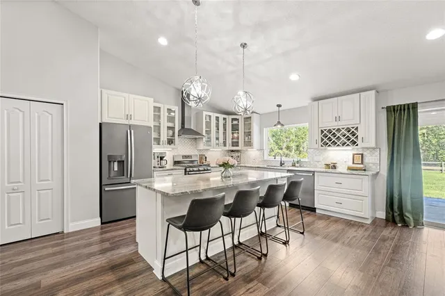 a kitchen with refrigerator a sink and chairs