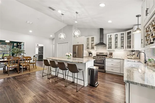 a kitchen with appliances a sink a counter top space and a center island