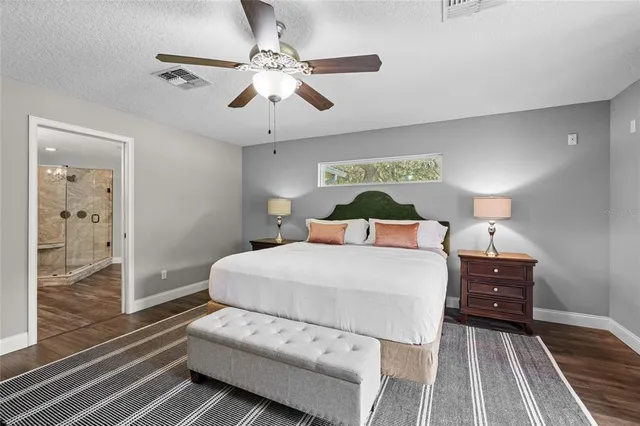 a bedroom with a large bed and a chandelier