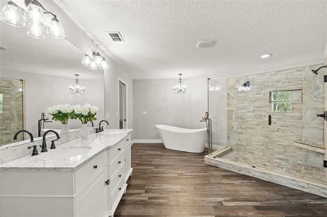 a bathroom with a double vanity sink a mirror and a bathtub