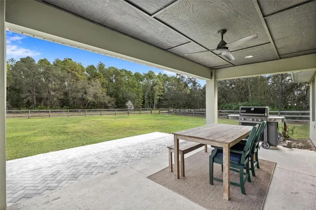 a view of a patio with dining table and chairs