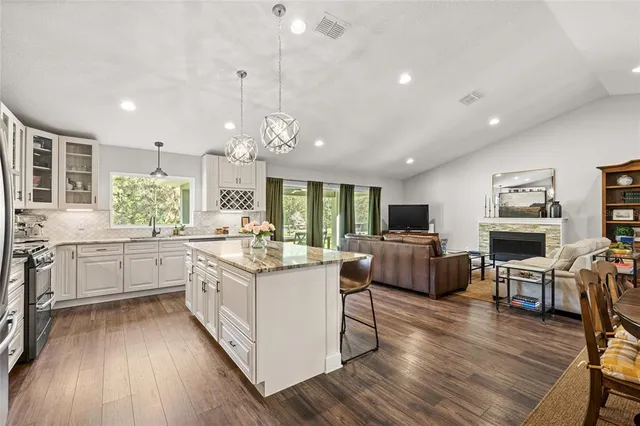 a kitchen with stainless steel appliances granite countertop sink stove top oven and cabinets