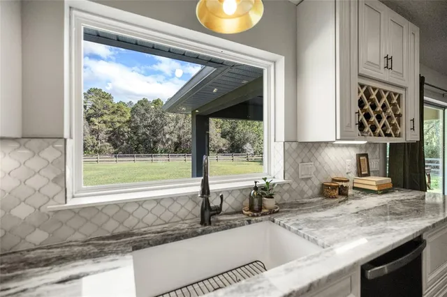 a kitchen with granite countertop a sink a counter top space and cabinets