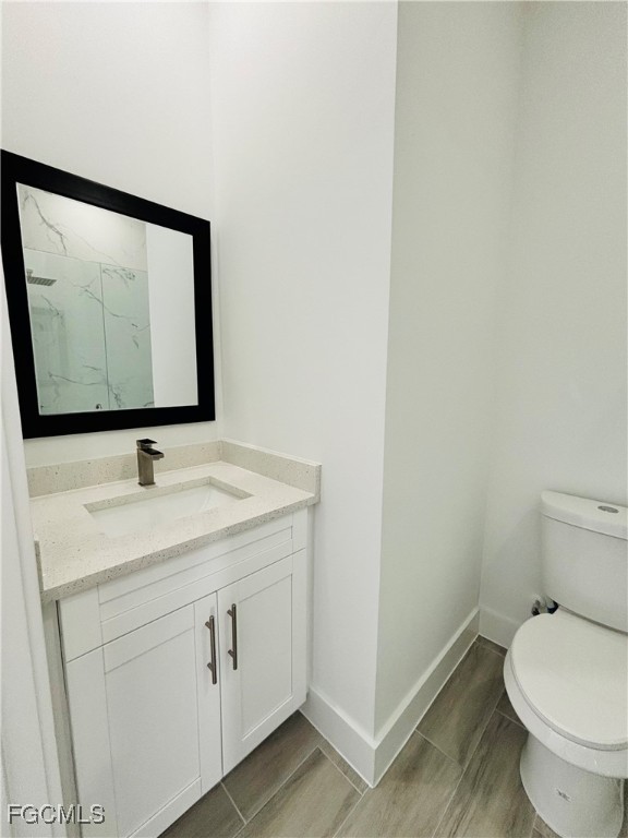 3010 45th Street Southwest Lehigh Acres, FL 33976 - Photo 15 of 29 a bathroom with a toilet sink and mirror