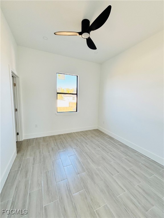 3010 45th Street Southwest Lehigh Acres, FL 33976 - Photo 19 of 29 an empty room with wooden floor cabinet and windows