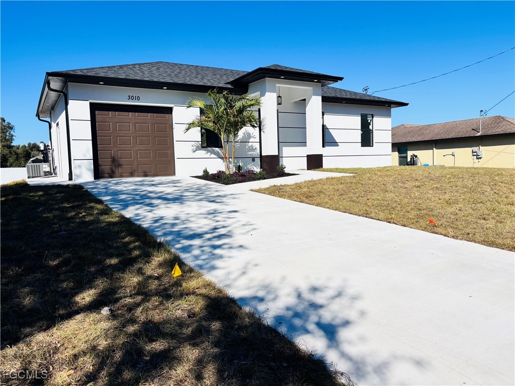3010 45th Street Southwest Lehigh Acres, FL 33976 - Photo 2 of 29 a front view of a house with a yard