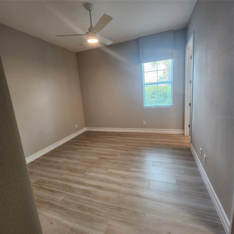512 Blue Shell Loop Sarasota, FL 34240 - Photo 28 of 44 an empty room with wooden floor and windows