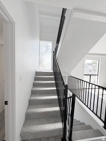 227 South West Lane Provo, UT 84601 - Photo 9 of 25 Open-concept staircase featuring light gray carpeting and a contrasting black metal railing