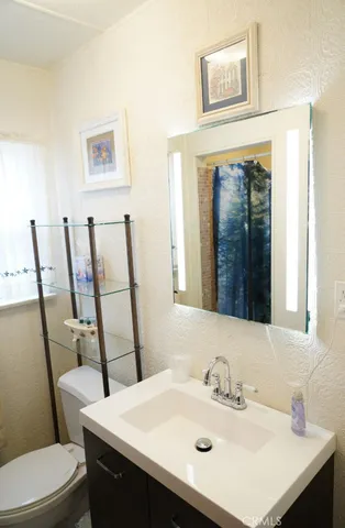a bathroom with a sink mirror vanity and toilet