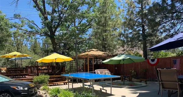 a view of patio with chairs and table under an umbrella with barbeque grill and umbrella