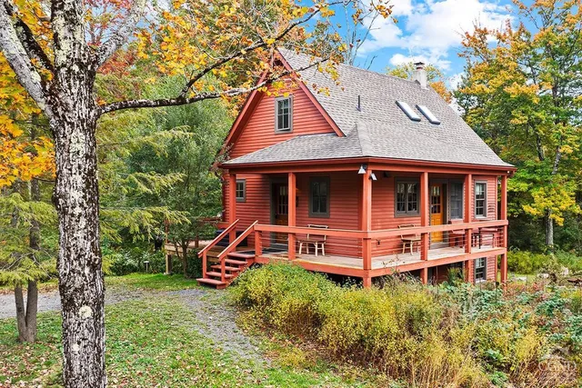 a backyard of a house with large trees and plants