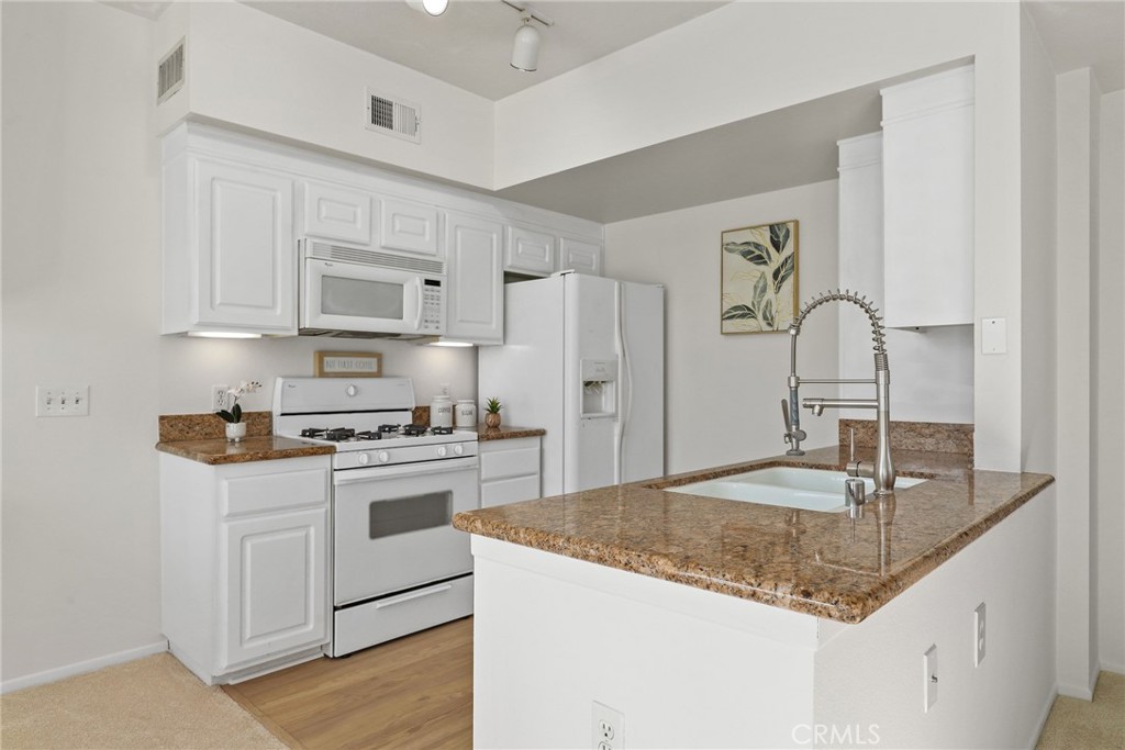20000 Plum Canyon Road, Unit 221 Saugus, CA 91350 - Photo 7 of 30 a kitchen with stainless steel appliances granite countertop a sink stove and refrigerator