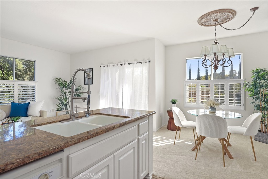 20000 Plum Canyon Road, Unit 221 Saugus, CA 91350 - Photo 9 of 30 a dining room with granite countertop furniture and a chandelier