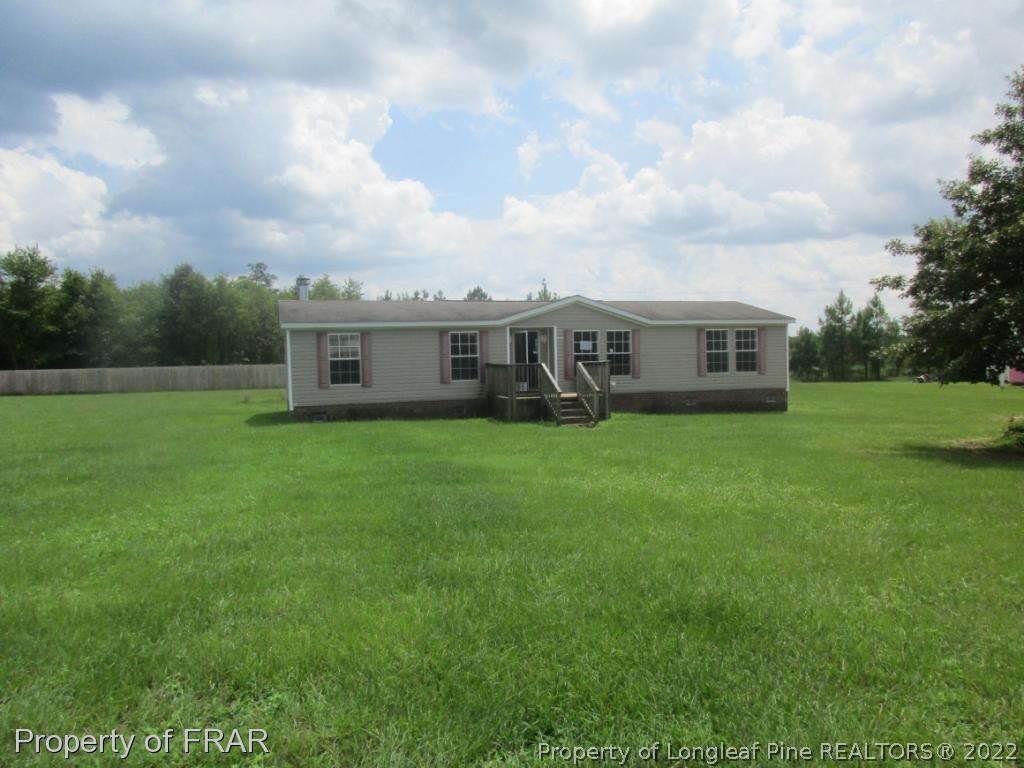 794 Wiggins Road Clinton, NC 28328 - Photo 1 of 18 a view of a house with a big yard and large trees