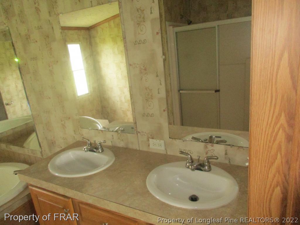 794 Wiggins Road Clinton, NC 28328 - Photo 15 of 18 a bathroom with a sink and a mirror