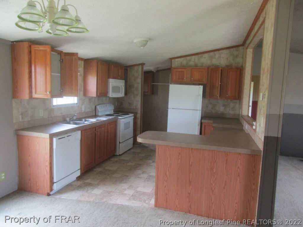 794 Wiggins Road Clinton, NC 28328 - Photo 4 of 18 a kitchen that has a sink and a stove in it