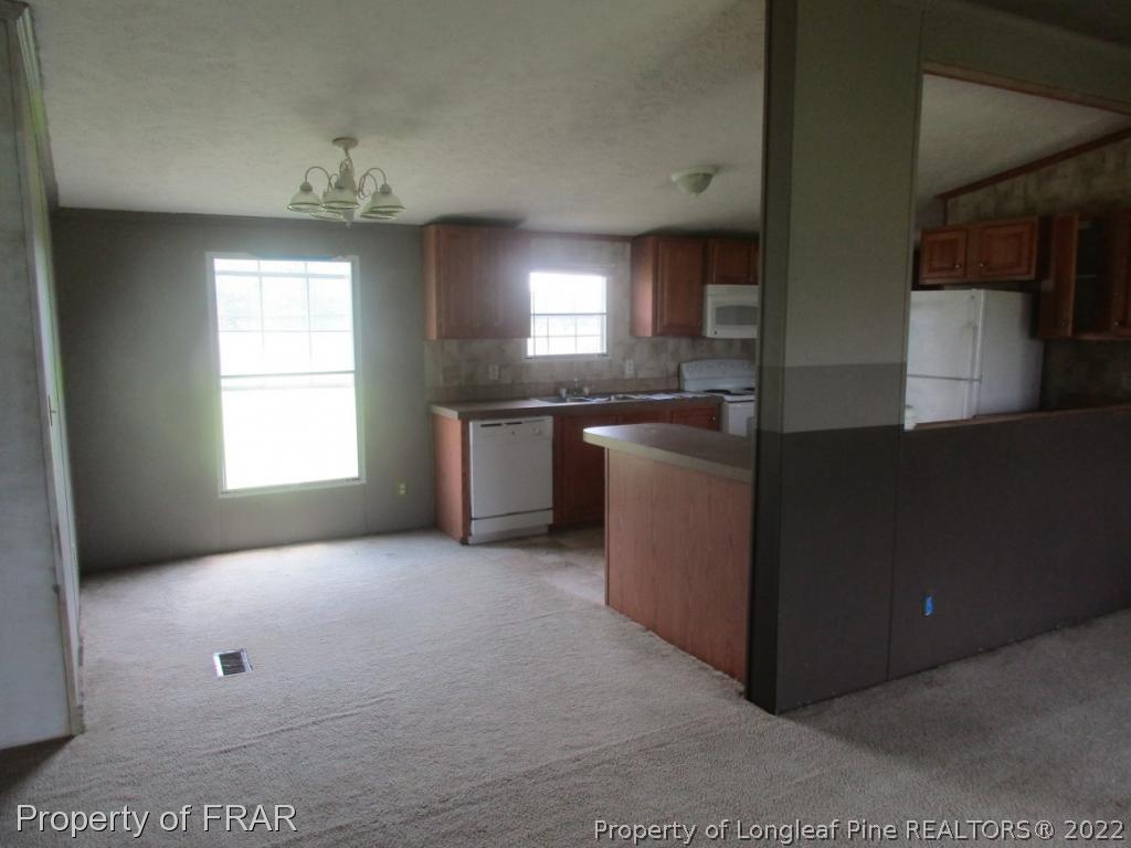 794 Wiggins Road Clinton, NC 28328 - Photo 8 of 18 a kitchen with stainless steel appliances granite countertop a stove a sink and a refrigerator