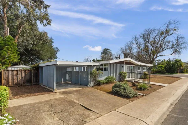 a front view of house with yard and trees around