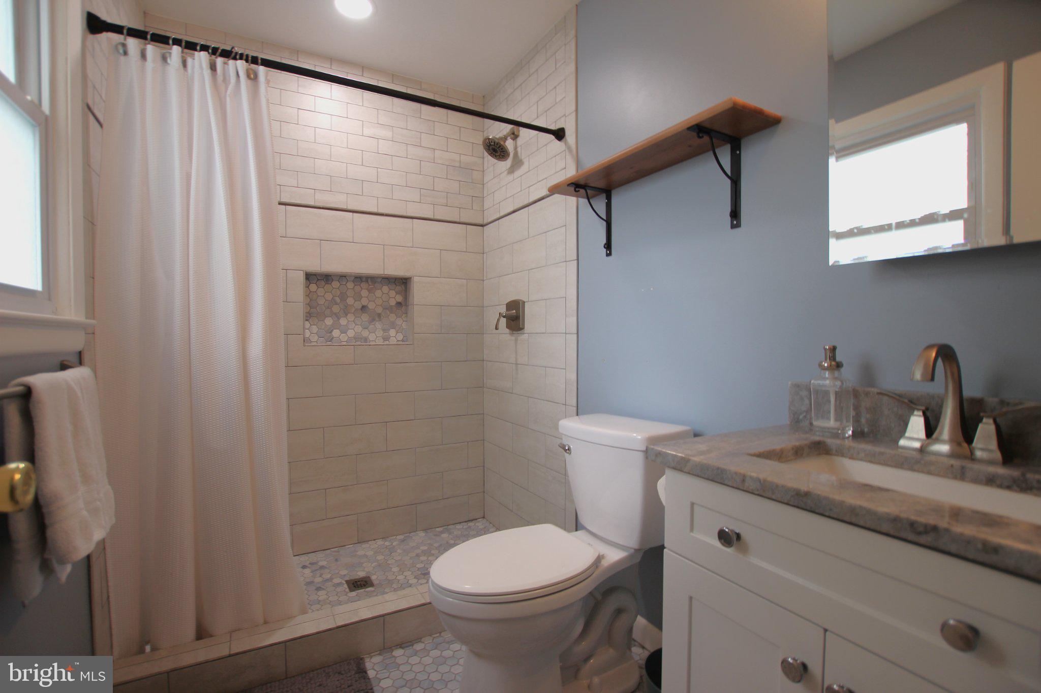 8502 Ivybridge Court Springfield, VA 22152 - Photo 20 of 31 a bathroom with a granite countertop sink toilet and shower