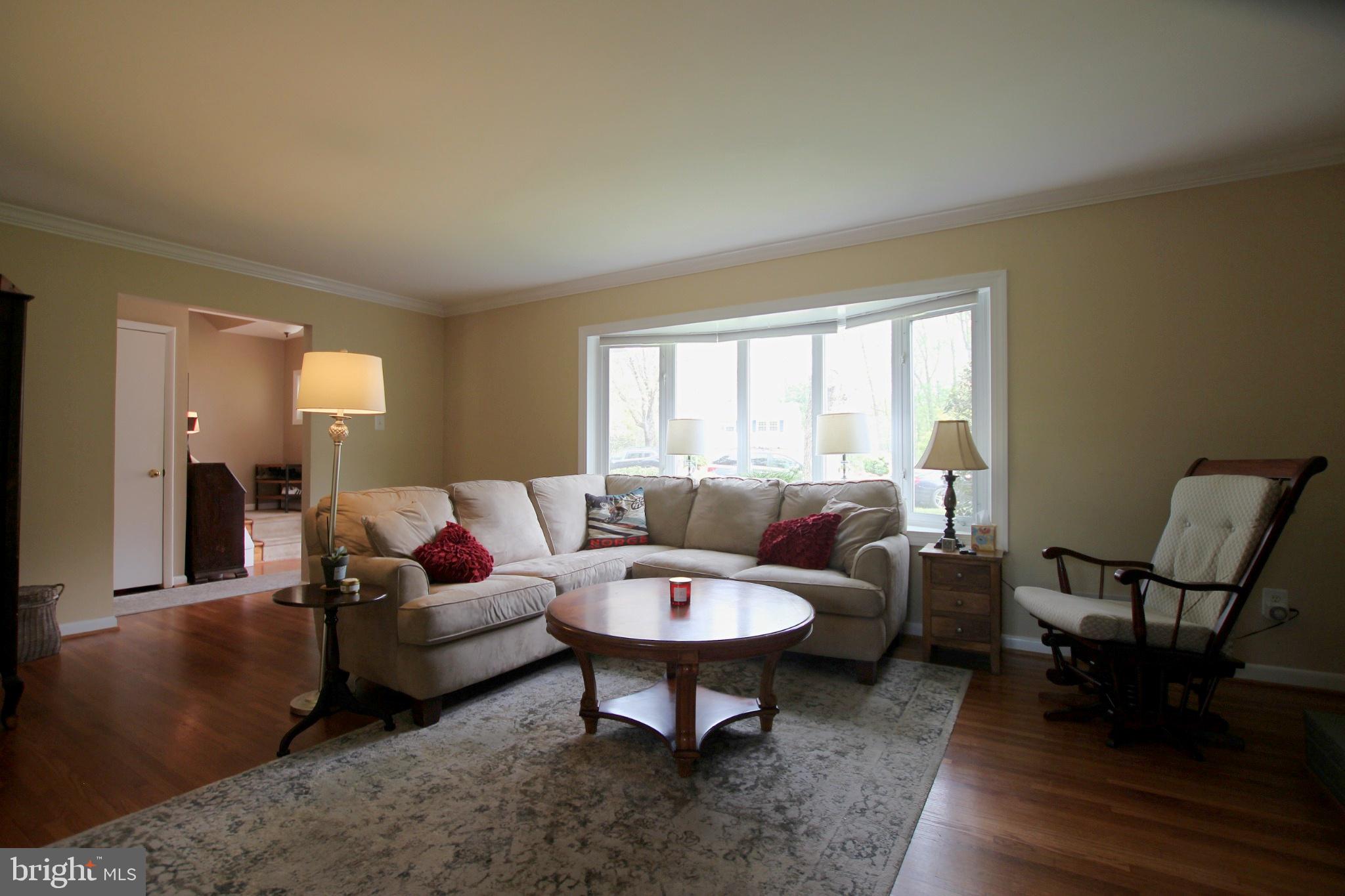 8502 Ivybridge Court Springfield, VA 22152 - Photo 4 of 31 a living room with furniture a lamp a rug and a large window