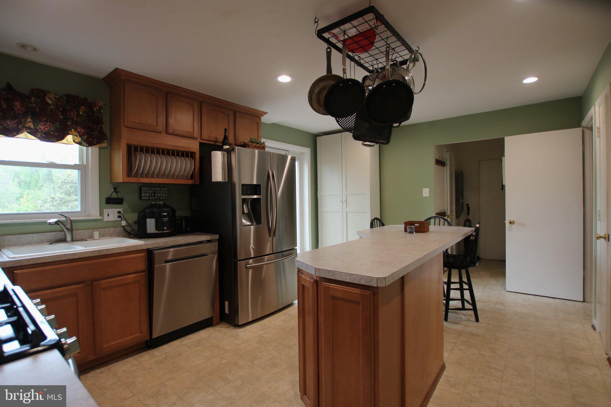 8502 Ivybridge Court Springfield, VA 22152 - Photo 7 of 31 a kitchen with stainless steel appliances a refrigerator a sink a stove a dining table and chairs