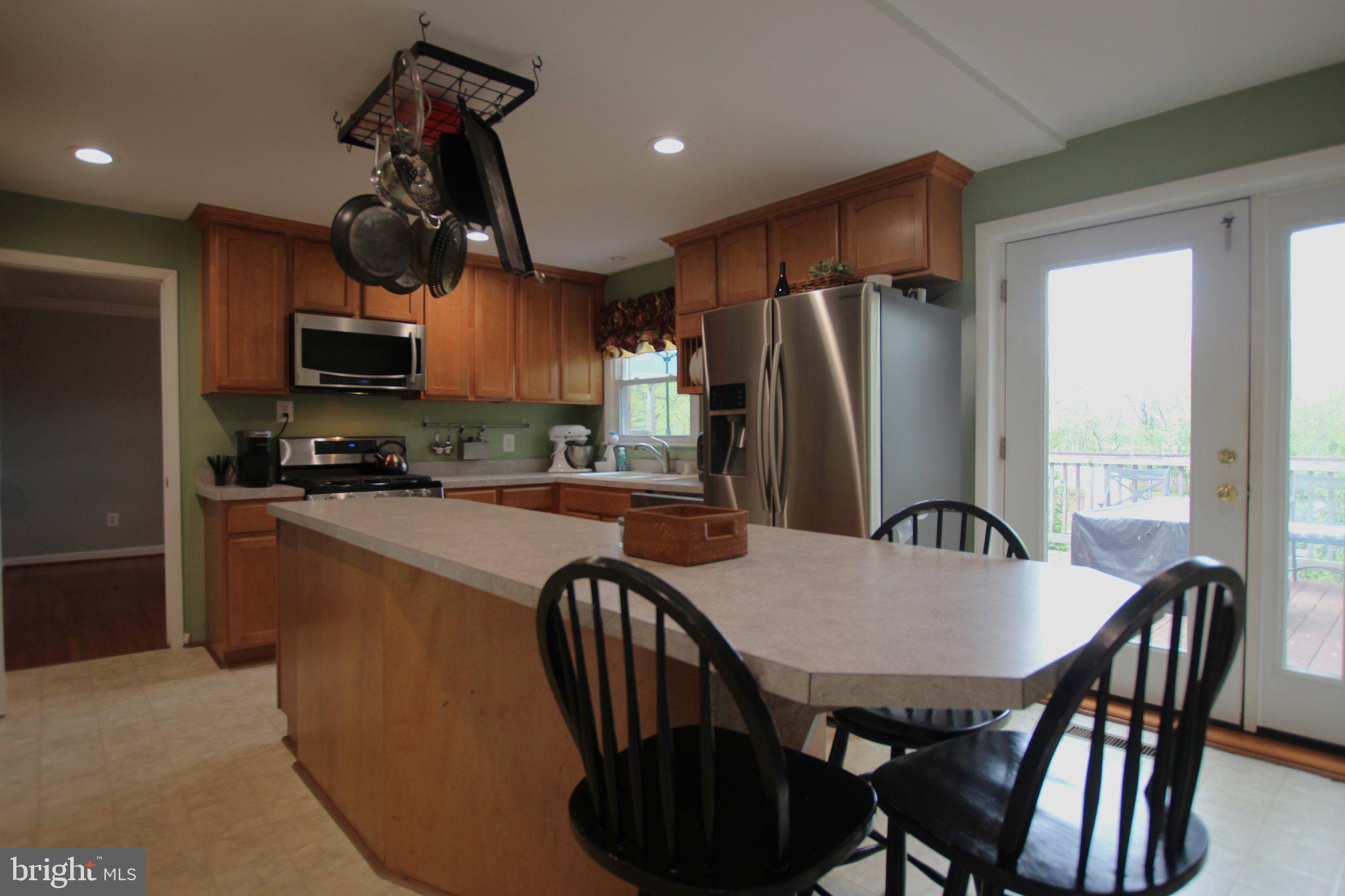 8502 Ivybridge Court Springfield, VA 22152 - Photo 9 of 31 a kitchen with stainless steel appliances granite countertop a stove a refrigerator a dining table and chairs
