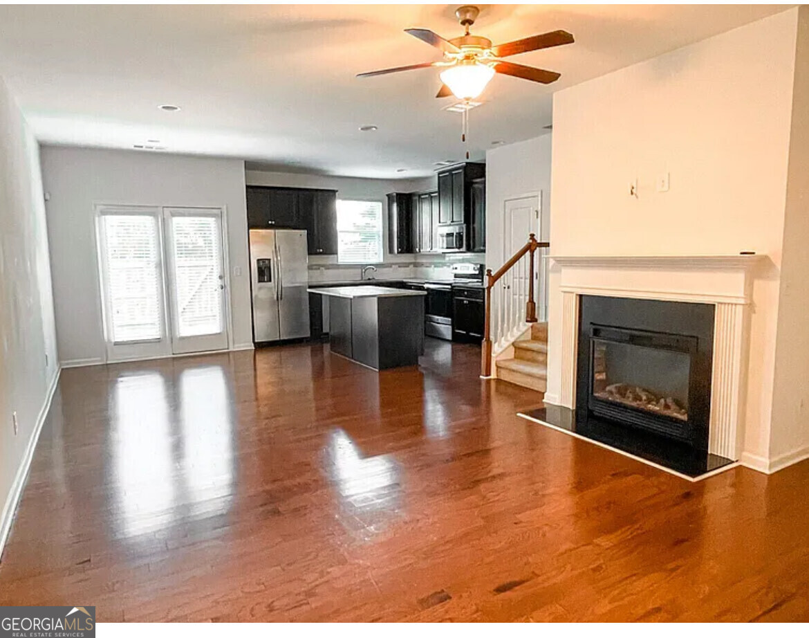 2686 Avanti Way Decatur, GA 30035 - Photo 3 of 6 a living room with stainless steel appliances kitchen island granite countertop a fireplace a flat screen tv and a fireplace