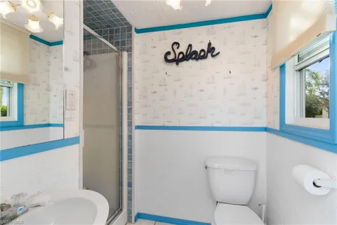 a bathroom with a toilet and a shower curtain