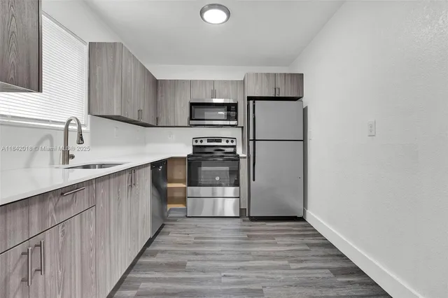 a kitchen with a refrigerator sink and cabinets