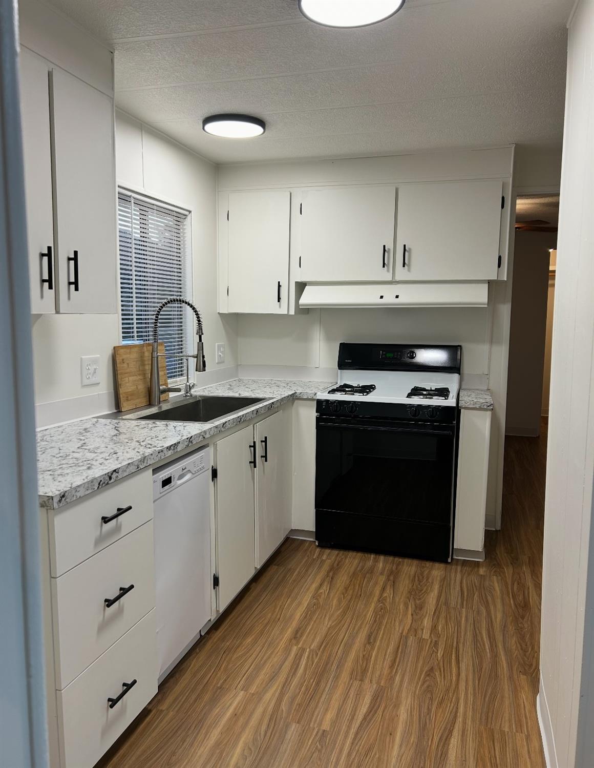 40845 Jean Road East Oakhurst, CA 93644 - Photo 7 of 16 a kitchen with granite countertop a stove a sink and wooden floor