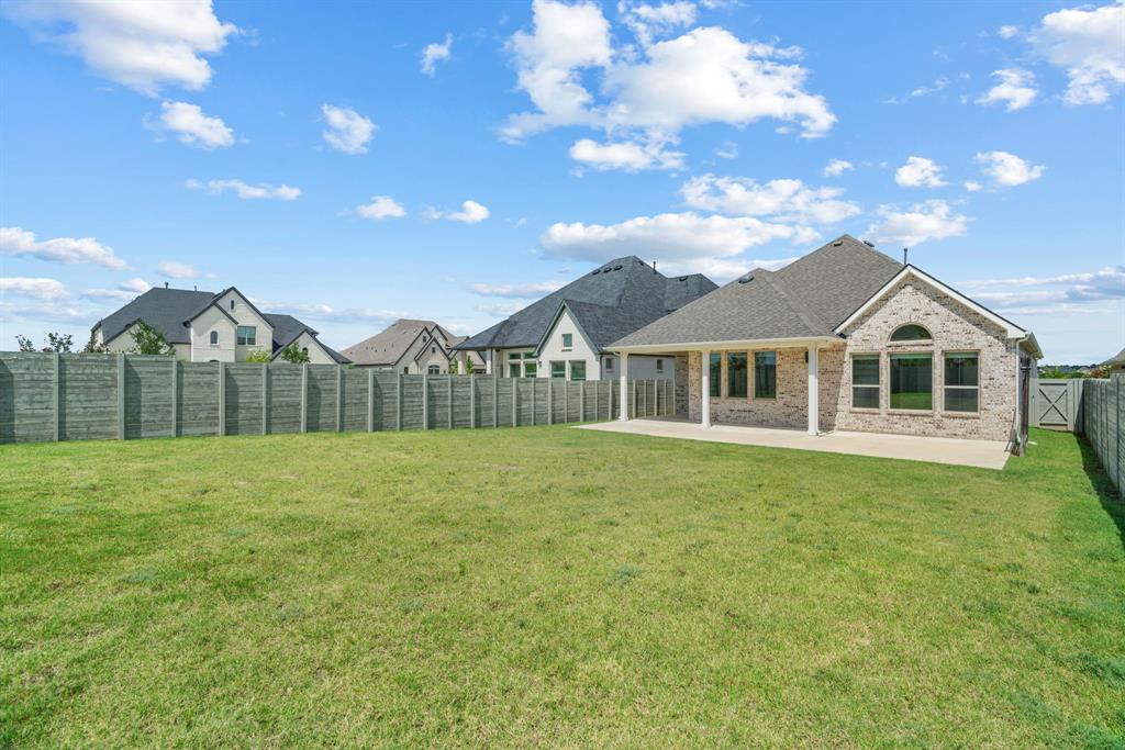 1821 Stonewall Road Argyle, TX 76226 - Photo 32 of 40 Expansive backyard featuring a manicured lawn, a covered patio, and a privacy fence
