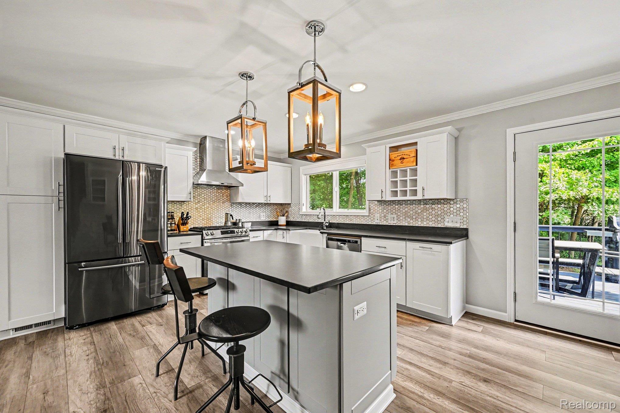 2104 Highfield Road Waterford, MI 48329 - Photo 6 of 38 Kitchen featuring white shaker cabinetry, LVP flooring, quartz countertops, a central island with seating, stainless appliances, and recessed lighting