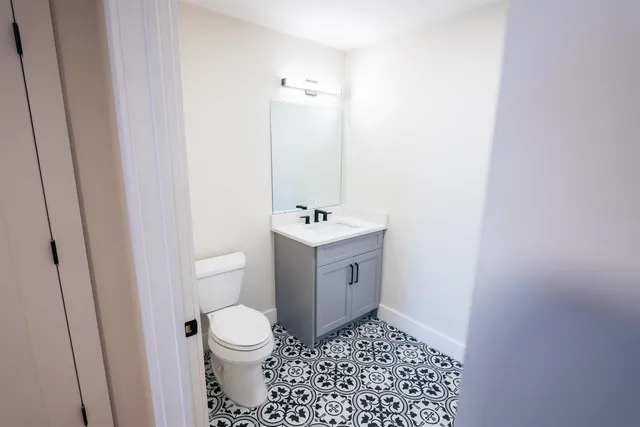 a bathroom with a sink a toilet and a mirror