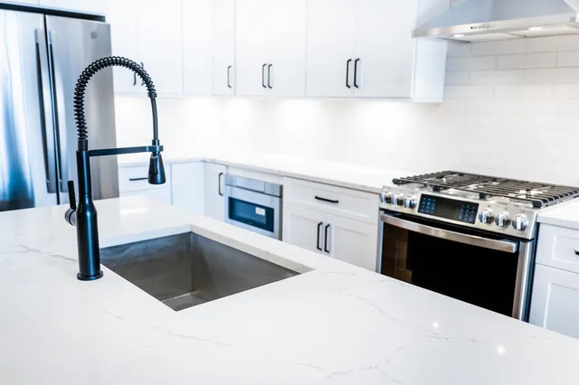 a kitchen with granite countertop a stove top oven and sink