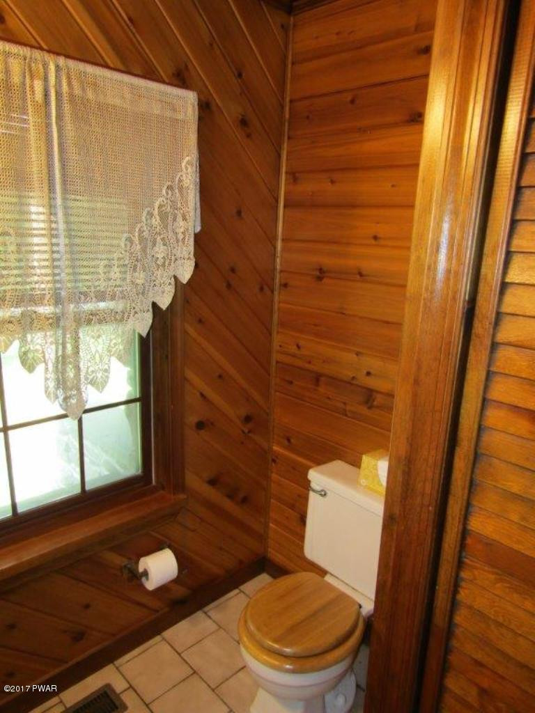 227 Hemlock Grove Road Newfoundland, PA 18445 - Photo 32 of 49 a bathroom with a toilet and a shower curtain