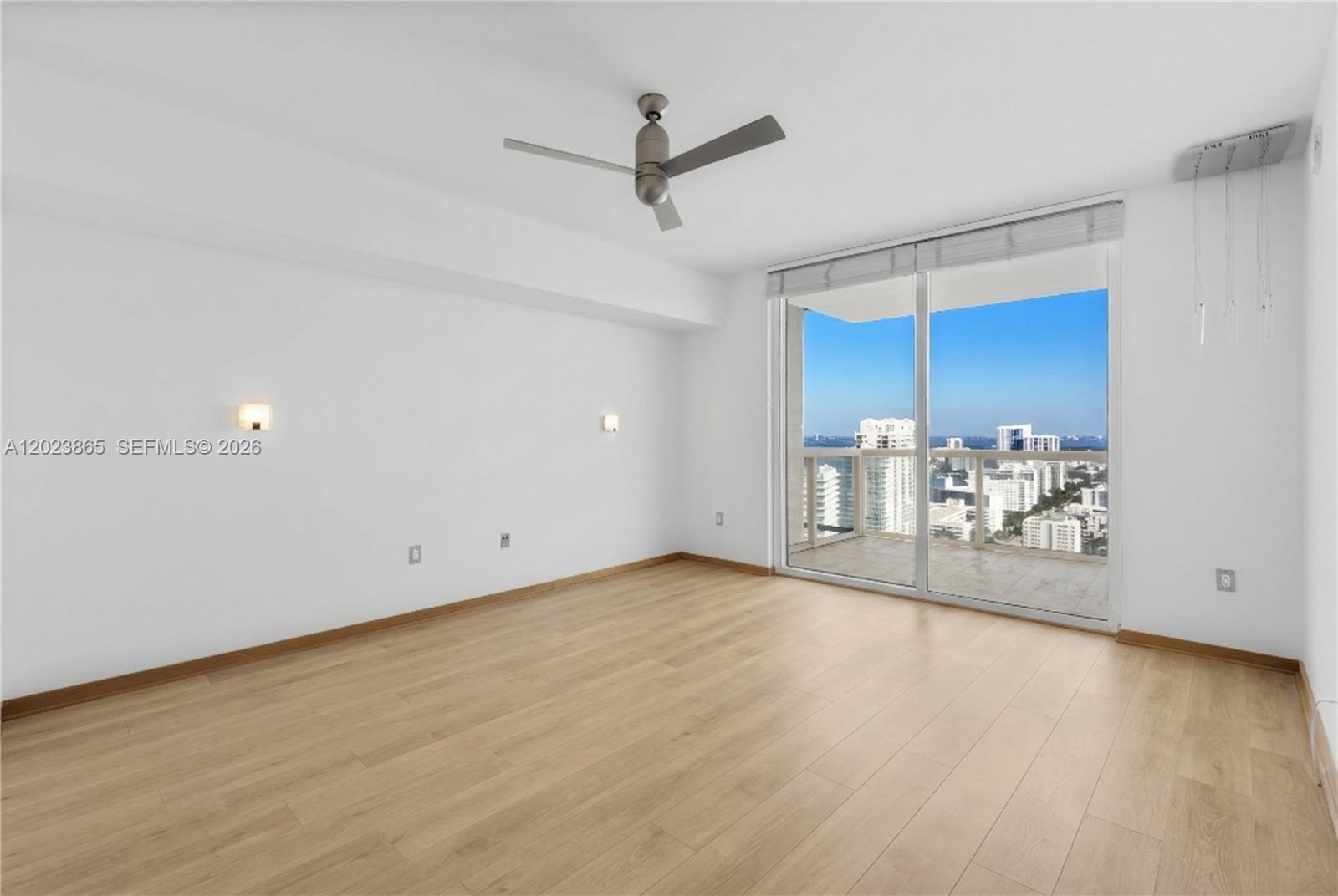 450 Alton Road, Unit 3206 Miami Beach, FL 33139 - Photo 10 of 25 an empty room with wooden floor and windows