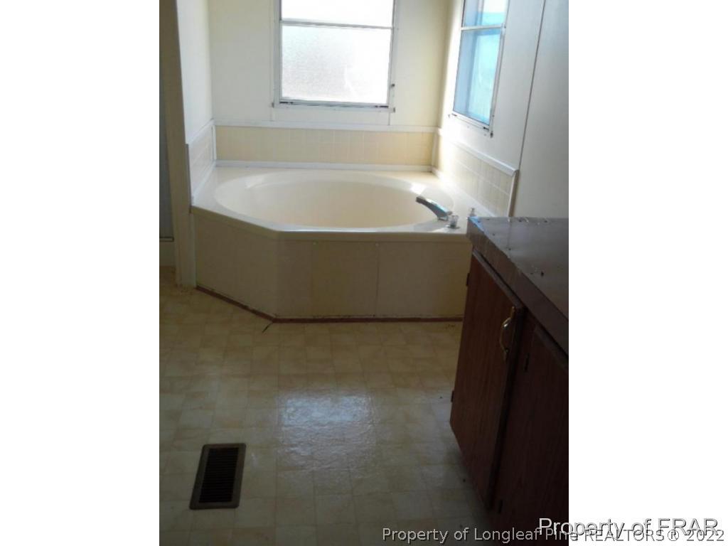 4832 Backbay Road Fayetteville, NC 28306 - Photo 13 of 18 a bath tub sitting in a bathroom next to a sink