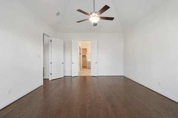 a view of an empty room with window and wooden floor