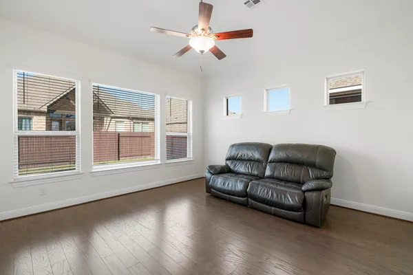 a view of a room with wooden floor and a kitchen