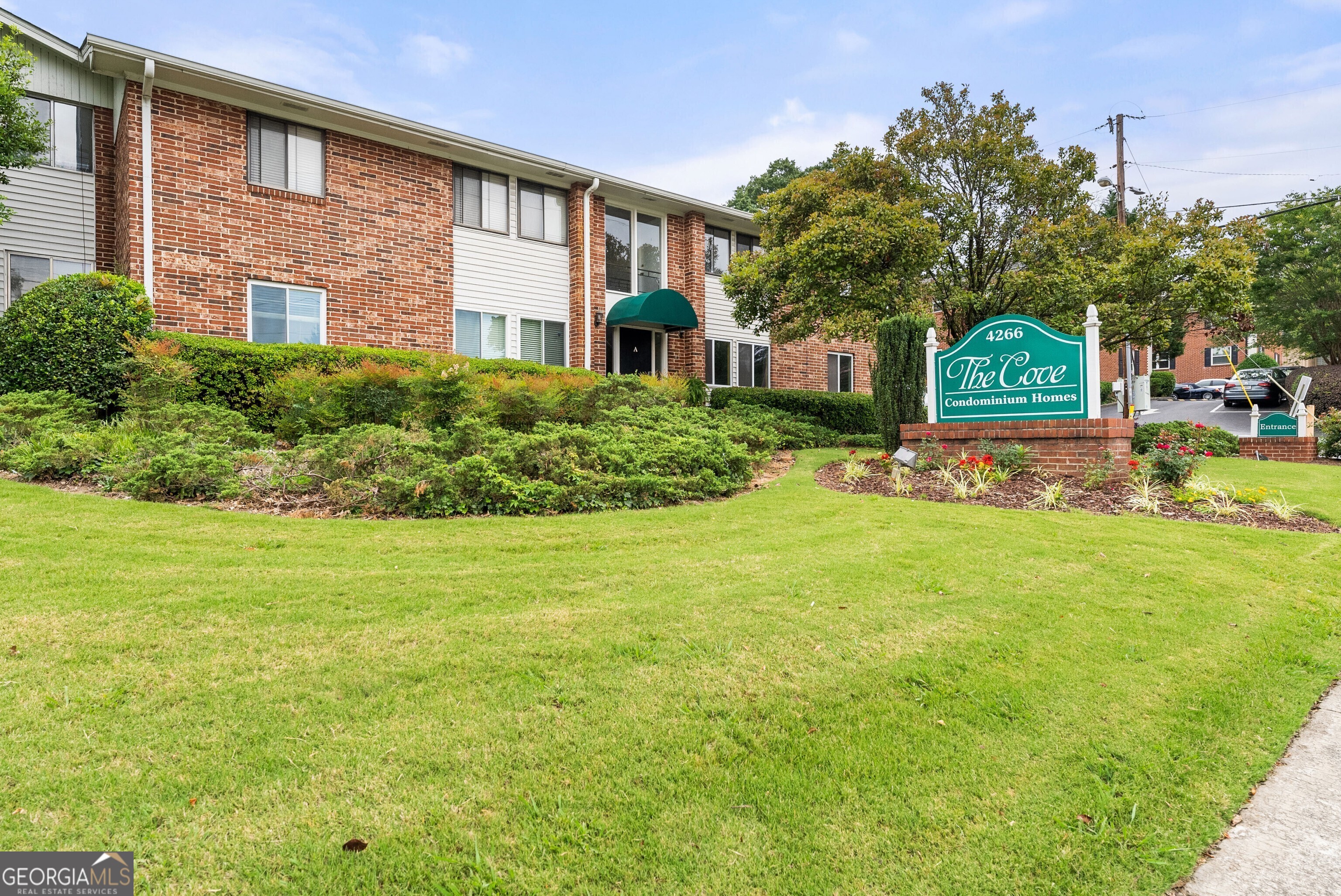 a front view of a house with a garden and trees