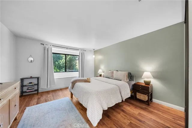 a bedroom with a bed and wooden floor