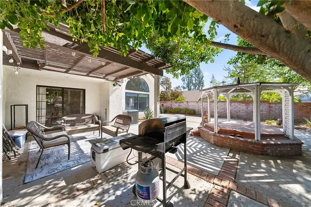 a view of a patio with a table and chairs under an umbrella