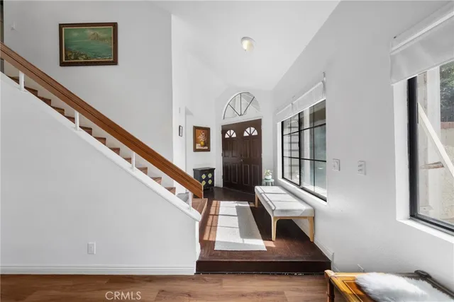 a living room with furniture stairs and a window