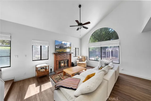 a living room with furniture a fireplace and a flat screen tv