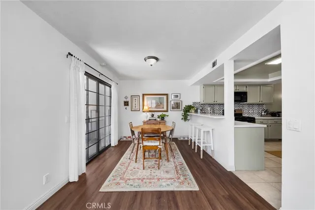 a living room with furniture wooden floor and a kitchen view