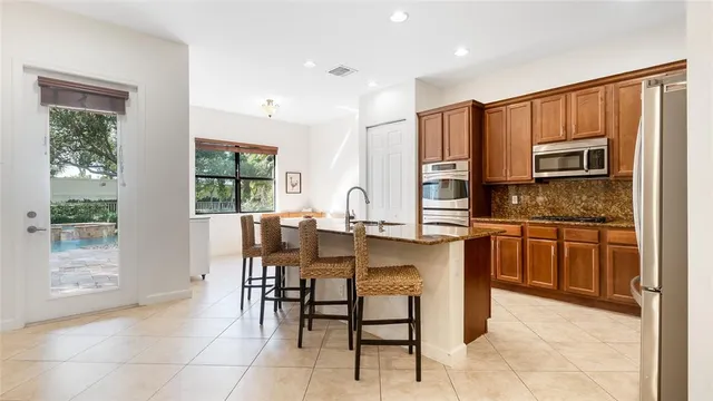a kitchen with stainless steel appliances granite countertop a refrigerator and cabinets